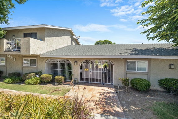 Front view of a two-story house with gated entry.