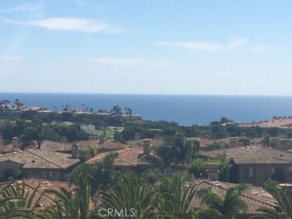 Panoramic view of residential rooftops and the ocean in the background.