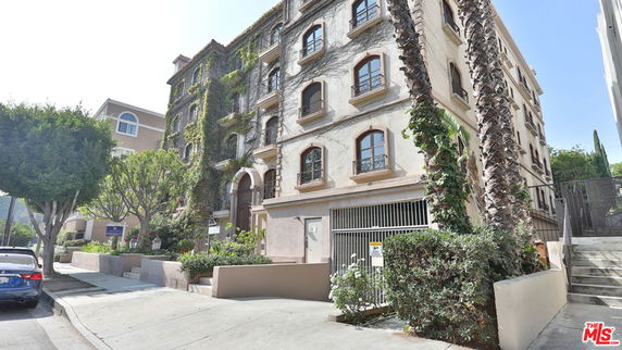 Front view of a multi-story building with ivy-covered facade and arched entrance.