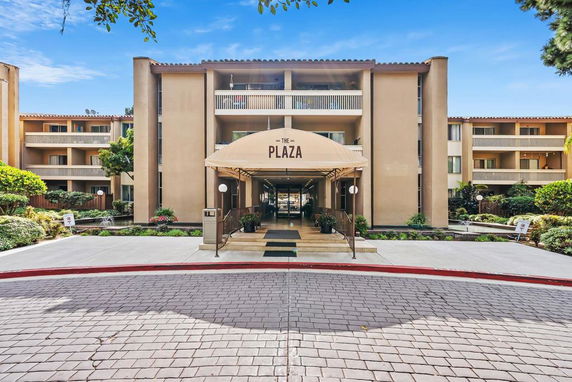 Front view of a multi-story residential building with balconies and an entrance canopy labeled 'The Plaza'.