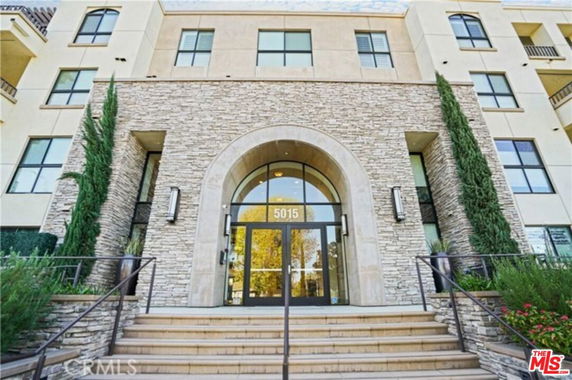 Front view of a multi-story building with stone and glass entrance.