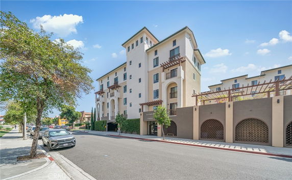 Front view of a multi-story residential building with balconies and decorative elements.