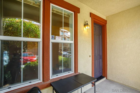 Front view of a house entrance with a door and windows.