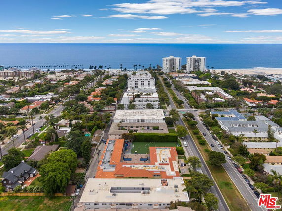 Aerial view of a coastal cityscape with multiple buildings and the ocean in the background.