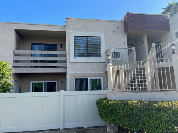 Front view of a two-story apartment building with balconies and stair access.