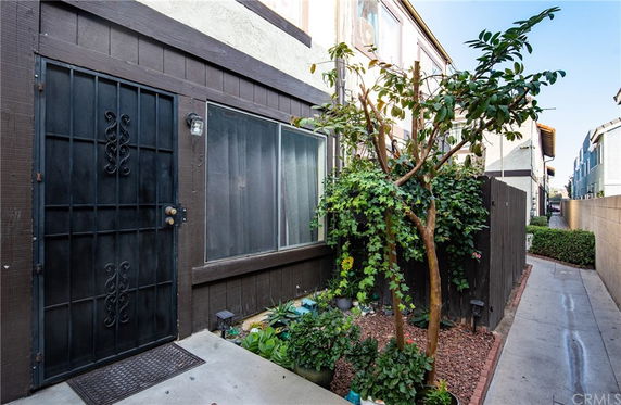 Front view of a townhouse with a side entrance and metal security door.