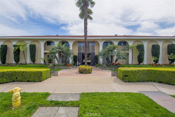 Front view of a two-story building with arches and a pathway leading up to the entrance.
