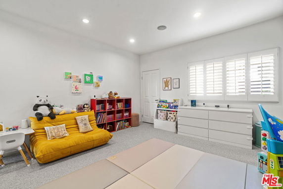Room with toys, books, and play mats, designed for children's activities.