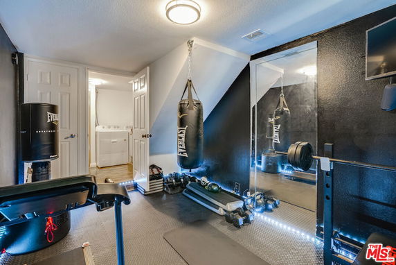 Indoor gym area with exercise equipment and punching bags.