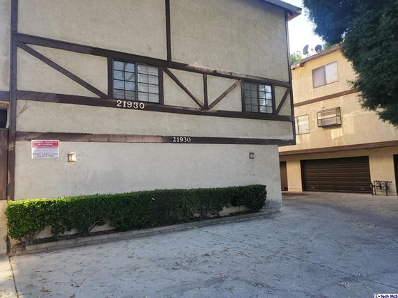 Front view of a multi-story residential building with visible garage doors.