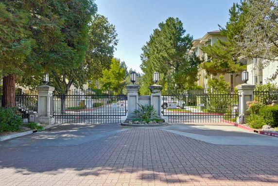 Front view of a gated entrance to a residential complex with a path leading inside.