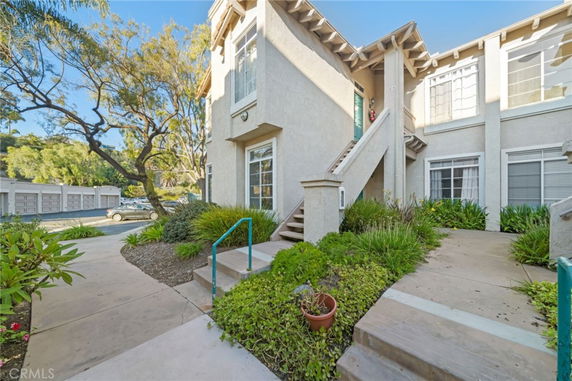 Front view of a multi-story residential building with external staircase.