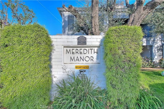 Front view of a building with a wall sign stating 'Meredith Manor'.