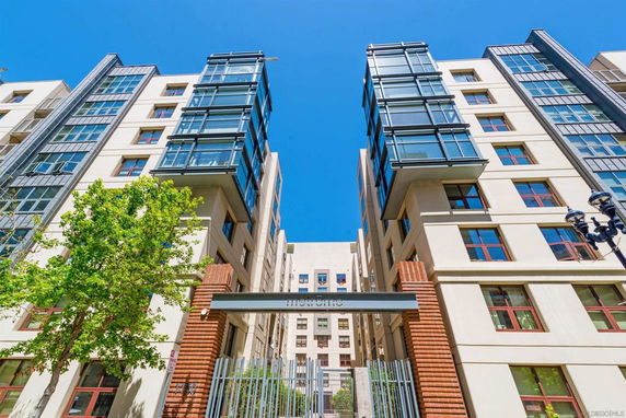 Front view of a modern multi-story residential building with glass balconies.