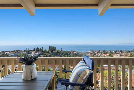 Panoramic view from a terrace overlooking the ocean and coastal town.