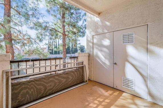 Outdoor balcony area overlooking trees and nearby buildings
