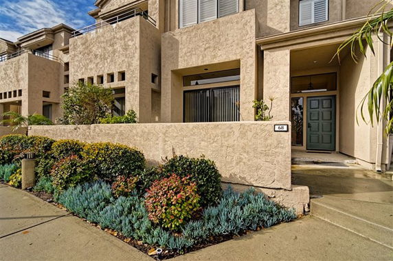 Front view of a multi-story house with a textured facade and entrance steps.