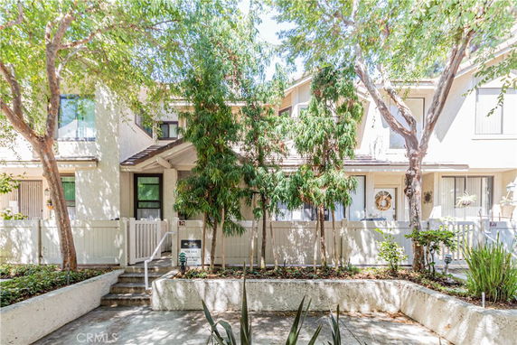 Front view of a two-story residential building with a small entrance gate.