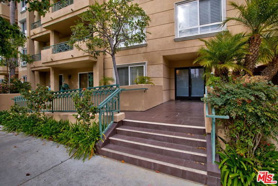 Front view of a multi-story building with balconies and entrance steps