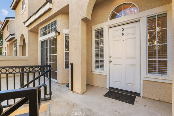 Front view of a house with a white door and surrounding windows.