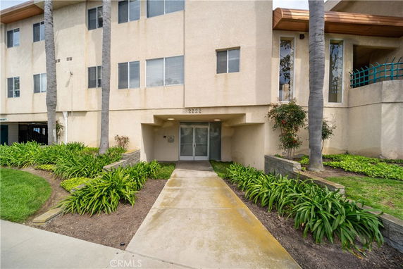 Front view of a multi-story building with a pathway leading to the entrance.