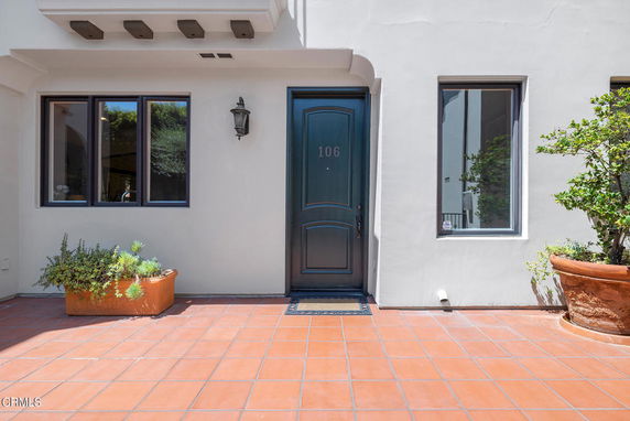 Front view of a house entrance with a blue door and two windows.