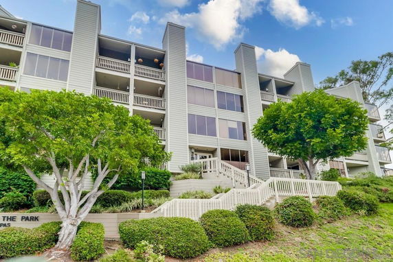 Front view of a multi-story residential building with balconies and large windows.
