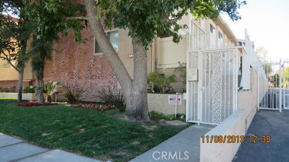 Front view of a multi-story building with gated entrance and brick facade.