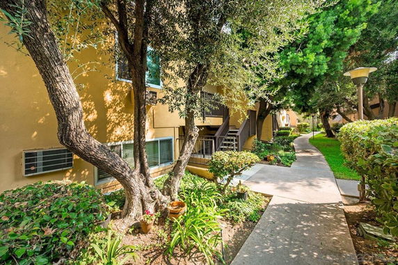 Exterior view of a building with a walkway and surrounding greenery.