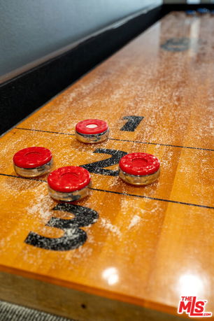 Shuffleboard table with red weights in an indoor recreation area.