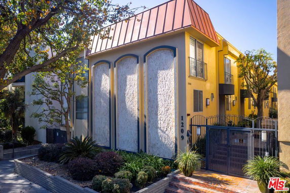 Front view of a multi-story yellow building with decorative stone elements.