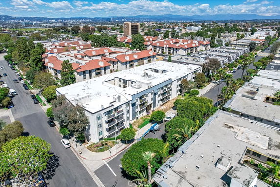 Aerial panoramic view of a residential area featuring multiple apartment buildings with white and red roofs.