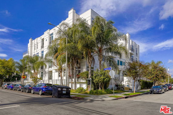 Front view of a modern multi-story apartment building with balconies.