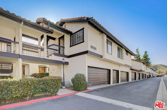 Front view of a multi-unit building with garages on the ground level.