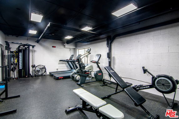 Indoor gym area with exercise equipment, including treadmills and weight machines.