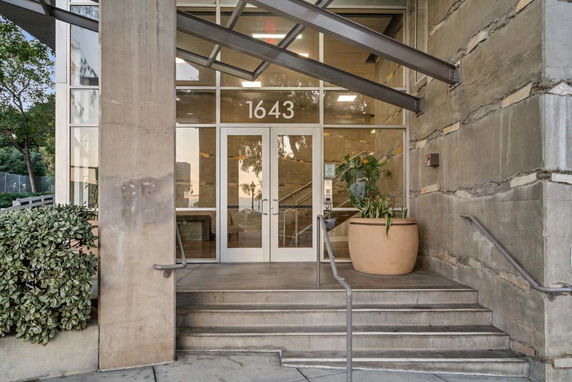 Entrance view of a building with glass doors and a staircase.