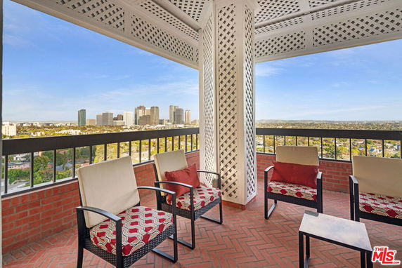 Panoramic view from a covered outdoor seating area with a skyline backdrop.