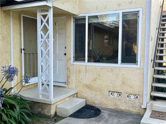 Front view of a house entrance with a small porch and stairs.