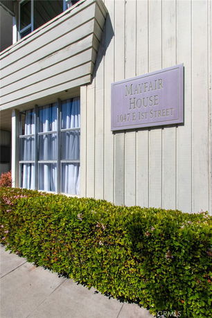 Exterior view of a house with a sign reading 'Mayfair House 1047 E 1st Street' on the wall.