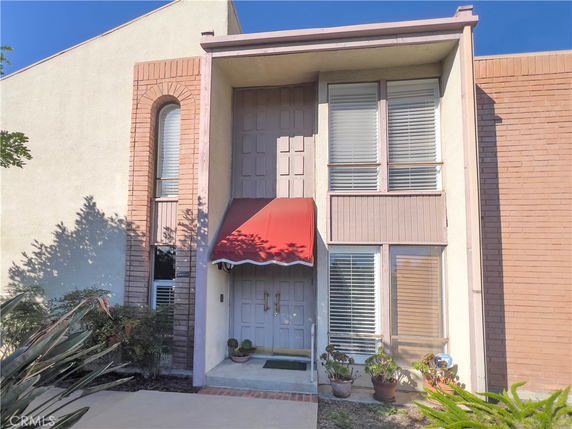 Front view of a two-story house with a red awning and multiple windows.