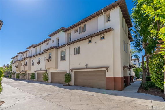 Front view of multiple townhouses with garages and balconies.