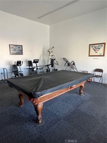 Room with a pool table and gym equipment.