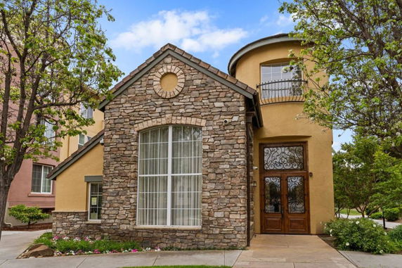 Front view of a two-story house with stone and stucco facade.