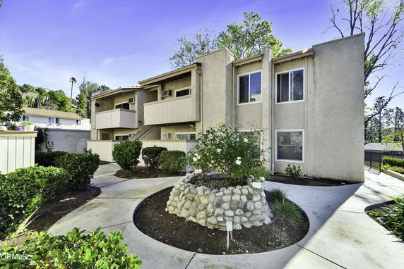 Front view of a two-story building with balconies and a walkway.