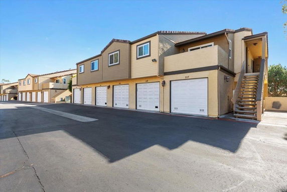 Front view of a multi-unit residential building with garages underneath.