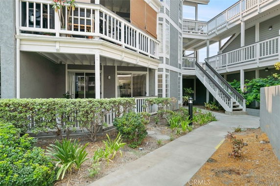 Front view of a multi-story building with balconies and exterior staircases.