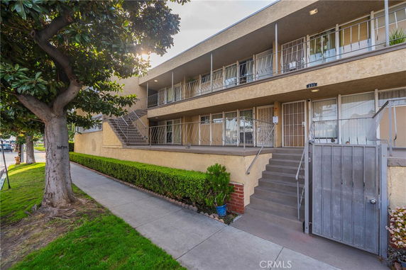 Front view of a two-story apartment building with stairs and balconies.