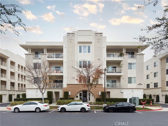 Front view of a multi-story apartment building with balconies.