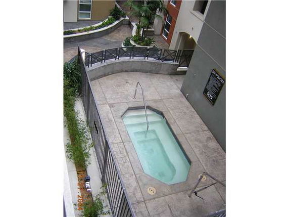 View of a small outdoor swimming pool with surrounding architecture.
