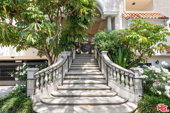 Front view of a house with a grand staircase and archway.